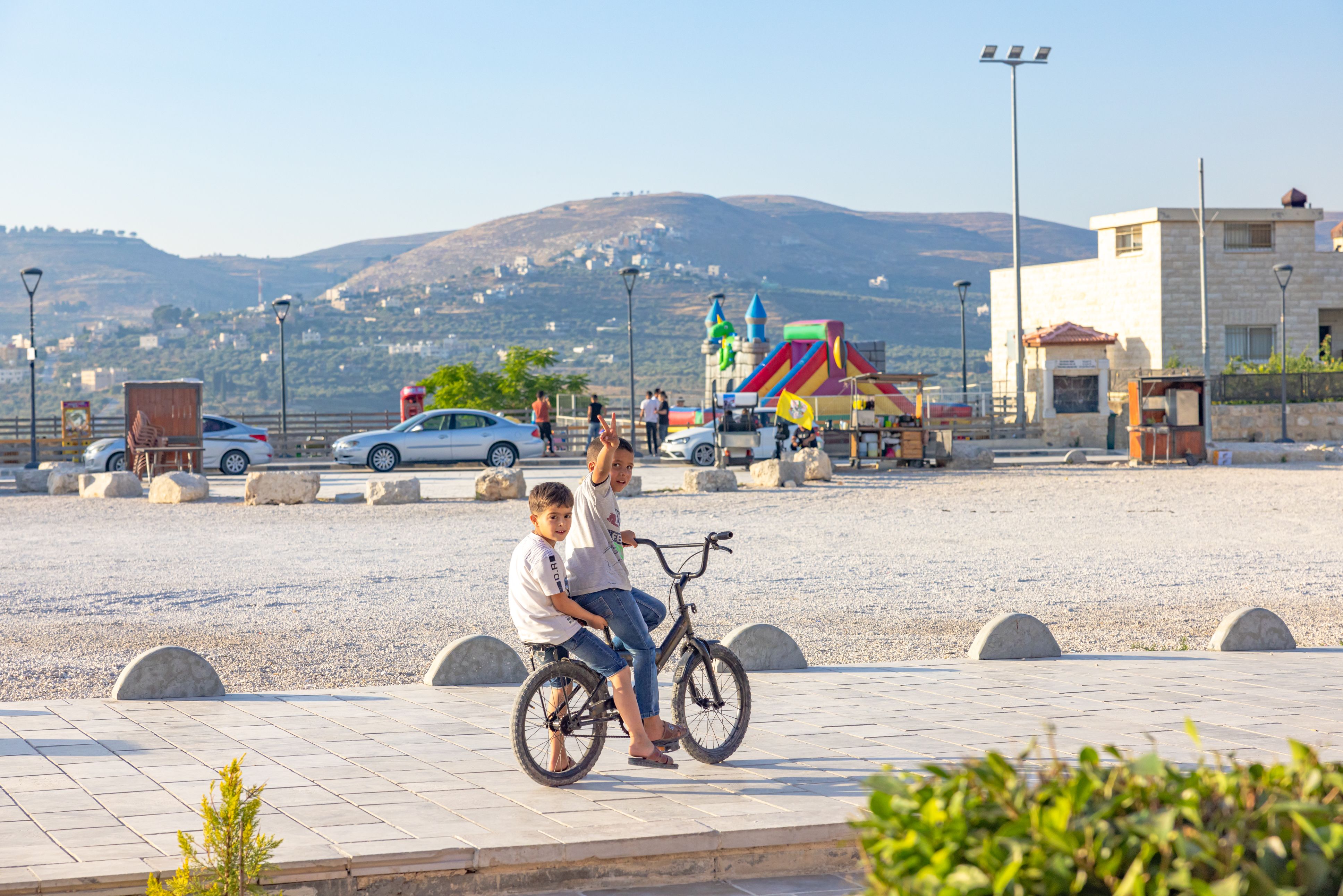 Two children on a bicycle in a West Bank town