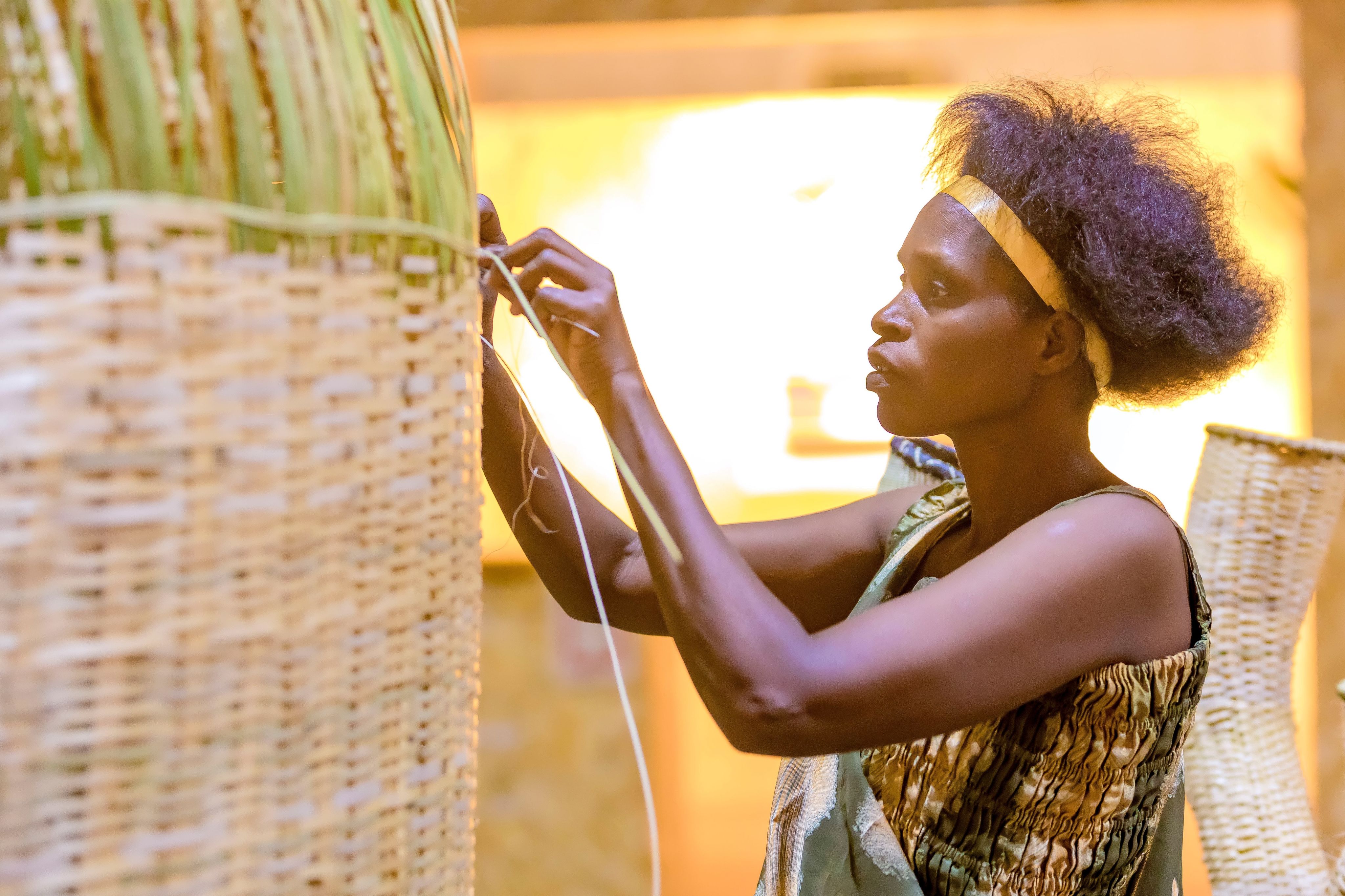 A Rwandan artist weaves a basket at the Awa Prize cereony in Kigali, 2023.