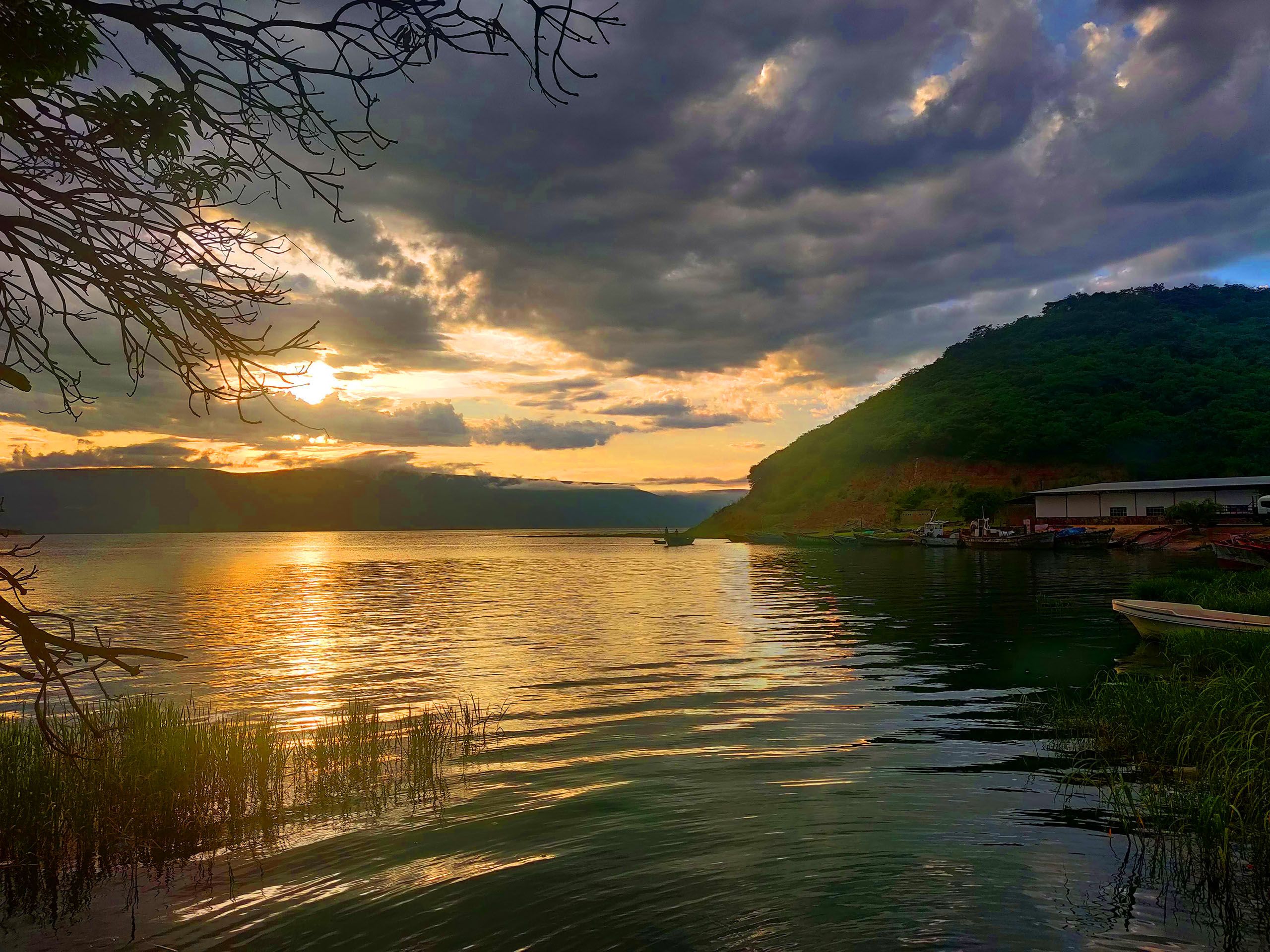 vue du lac avec des petits bateaux au soleil couchant